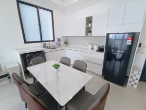 Infinity Pool, Urban Suites, Georgetown, 2 Car Parks by Star Home في جورج تاون: مطبخ مع طاولة بيضاء وثلاجة سوداء