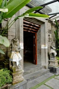 an entrance to a building with statues in front of it at ARTOTEL Haniman Ubud in Ubud