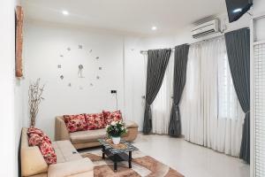 a living room with a couch and a table at Urbanview Hotel Syariah near RSIA Annisa Jelutung Jambi in Sultan Thaha Airport