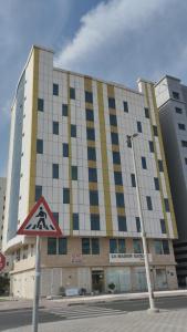 Four Star Royel Real Estate في أبوظبي: مبنى كبير أمامه علامة على الشارع