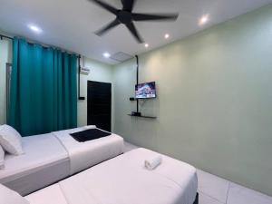 a bedroom with two beds and a ceiling fan at AR HOMESTAY & ROOMESTAY in Merlimau