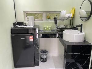 a bathroom with a counter with a sink and a mirror at AR HOMESTAY & ROOMESTAY in Merlimau