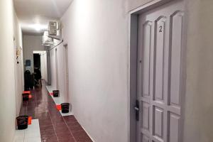KaranganyarRedDoorz near Juwata Airport 2 Tarakan的走廊设有白色门,铺有瓷砖地板 更多2张照片