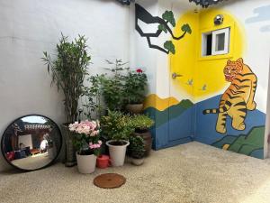 a wall with a mirror and potted plants in a room at Gilgaon Hanok Stay in Seoul
