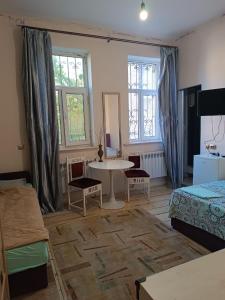a living room with a bed and a table and chairs at Номер в Гостевом доме у моря in Odesa