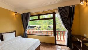 une chambre avec un lit et une grande fenêtre dans l'établissement La Mai Chau Home, à Mai Châu 122 autres photos