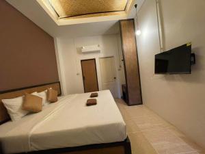 a bedroom with a bed with a flat screen tv on the wall at Sleep CNX in Chiang Mai