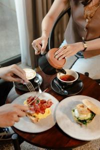 a group of people sitting at a table with plates of food at ARTOTEL Haniman Ubud in Ubud