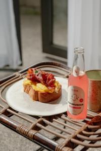 a sandwich on a plate on a table with a drink at ARTOTEL Haniman Ubud in Ubud