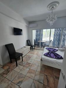 un soggiorno con un letto e un lampadario di Casa Mary a Eforie Nord Altre 54 foto