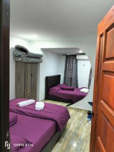 two beds in a room with a mirror at RJ design homestay in Kampong Batu Lapan