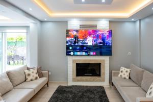 een woonkamer met een open haard en een flatscreen-tv bij Villa Moon - Tranquil 3BR Villa with Private Pool in Koycegiz