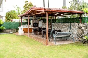 een houten terras met een tuinhuisje in de tuin bij Villa Moon - Tranquil 3BR Villa with Private Pool in Koycegiz