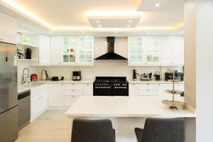 een keuken met witte kasten en een wit aanrecht bij Villa Moon - Tranquil 3BR Villa with Private Pool in Koycegiz