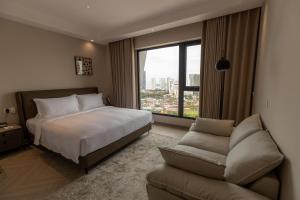 a hotel room with a bed and a couch at Landison Hotel Penang in George Town