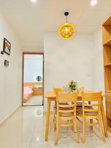 a dining room with a wooden table and chairs at X O HOMESTAY Nera Apartment Huế in Hue
