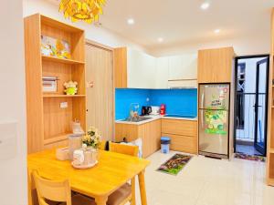 a kitchen with a wooden table and a refrigerator at X O HOMESTAY Nera Apartment Huế in Hue +19 photos