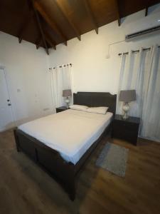 a bedroom with a bed with white sheets and two lamps at Itopia in Gros Islet