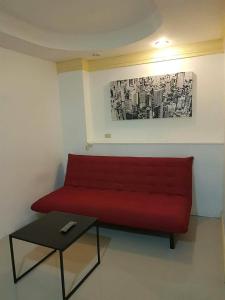 - un canapé rouge dans une chambre avec une table dans l'établissement Sea Breeze Patong Holiday Condo, à Patong Beach