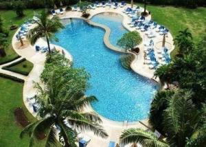 une vue aérienne d'une grande piscine avec des palmiers dans l'établissement Sea Breeze Patong Holiday Condo, à Patong Beach