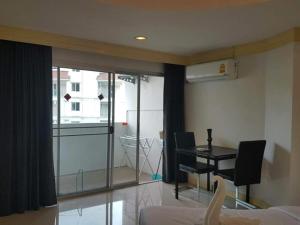 une chambre avec un lit, un bureau et une fenêtre dans l'établissement Sea Breeze Patong Holiday Condo, à Patong Beach