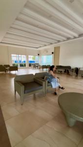 a woman sitting on a couch in a room at Dumaguete Marina Spatial Condo Unit in Dumaguete +42 photos