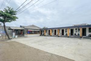 an empty parking lot in front of a building at RedDoorz at Pantai Sayangheulang Garut 2 in Cilauteureun