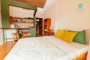 a bedroom with a large bed with yellow and green pillows at Rio Celeste Dreams in Bijagua