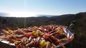 a plate of seafood on a table with the ocean in the background at Villa Eden Home Holiday in Santa Margherita di Pula