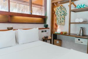 a bedroom with a bed with white pillows at Bravo Beach Resort in General Luna +70 photos