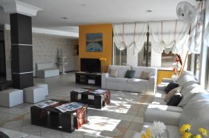 a living room with white couches and a tv at Hotel La Fontana in Termas de Río Hondo