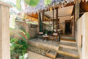 a staircase leading to a house with a table and chairs at Bravo Beach Resort in General Luna