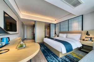a large bedroom with a large bed and a desk at Echarm Hotel Nanjing Lishui High-speed Railway Station Wuzhou Commercial City in Lishui +221 photos