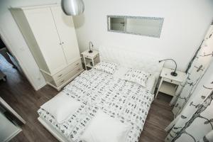 Habitación blanca con cama y espejo en Dadule Apartments, en Strožanac