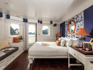 una camera con letto bianco e pareti blu di Bhaya Luxury Halong Cruise - Manage by LuxCruises a Ha Long