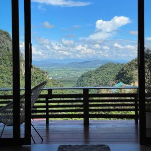 a chair on a porch with a view of the mountains at ViewNaaBaan At Phamee in Ban Pha Mi