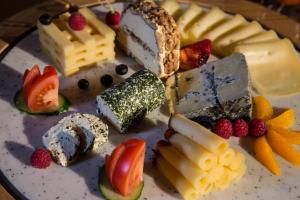 a plate of cheese and fruit on a table at Hotel Cheminee in Zermatt