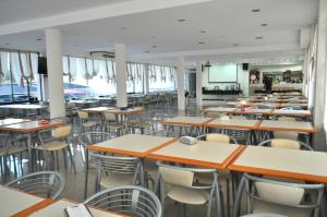 a cafeteria with tables and chairs and a screen at Hotel La Fontana in Termas de Río Hondo