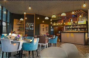 a restaurant with tables and chairs and a bar at Orbi Beach Tower in Batumi