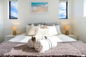 een slaapkamer met een wit bed met twee opgezette hoofden erop bij Stadium Suite on Southwark - Luxury in City Centre in Christchurch