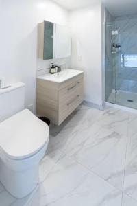 een badkamer met toilet, wastafel en douche bij Stadium Suite on Southwark - Luxury in City Centre in Christchurch