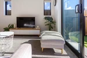 een woonkamer met een tv en een stoel bij Stadium Suite on Southwark - Luxury in City Centre in Christchurch