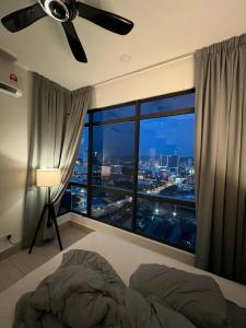 a bedroom with a ceiling fan and a large window at KL Sky Condo - Top Floor in Kuala Lumpur