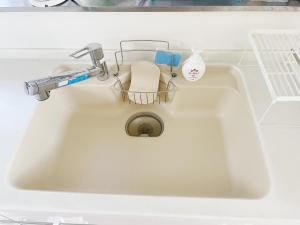 a white sink with a faucet and a bottle of soap at Kasukabe raku house in Kasukabe +29 photos