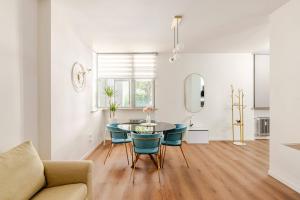 a living room with a table and blue chairs at LA MAR Apartment Treviso in Treviso