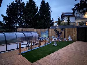 a backyard with a gazebo and artificial grass at MONTANA Wellness Apartman in Biatorbágy +6 photos