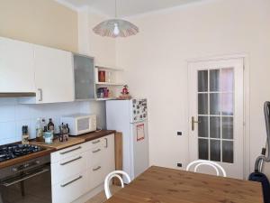 a kitchen with a white refrigerator and a table at Appartamento nel centro di Recco in Recco +6 photos