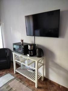a white table with a tv on a wall at Florentinas Apartment in Braşov