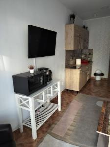 a living room with a television on a white stand at Florentinas Apartment in Braşov