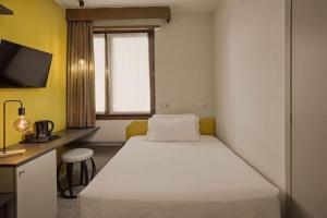 a bedroom with a bed and a desk and a window at Hotel Le Mura in Lazise